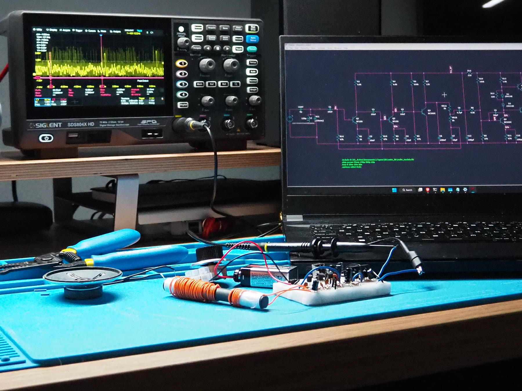 Radio receiver under test beside an oscilloscope and LTspice schematic